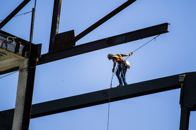An ironworker guides a beam into place at the MGM Resorts International-AEG arena construction site behind New York-New York casino-hotel onThursday, April 23, 2015. The $375 million arena is sch ...