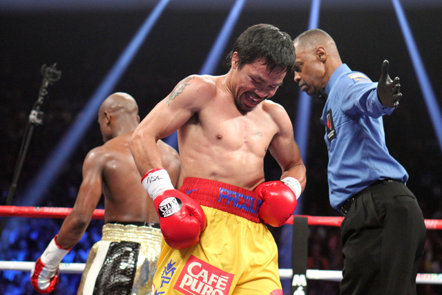 Manny Pacquiao and Floyd Mayweather Jr. head to their corners between rounds of their welterweight unification boxing match at the MGM Grand Garden Arena in Las Vegas on Saturday, May 2, 2015. (Sa ...