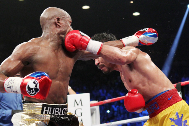 Manny Pacquiao hits Floyd Mayweather Jr. with a left during their welterweight unification boxing match at the MGM Grand Garden Arena in Las Vegas on Saturday, May 2, 2015. (Sam Morris/Las Vegas R ...