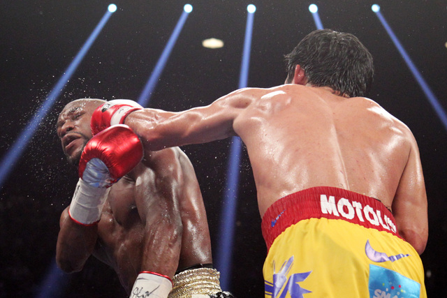 Manny Pacquiao hits Floyd Mayweather Jr. with a left during their welterweight unification boxing match at the MGM Grand Garden Arena in Las Vegas on Saturday, May 2, 2015. (Sam Morris/Las Vegas R ...
