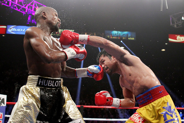 Manny Pacquiao hits Floyd Mayweather Jr. with a left during their welterweight unification boxing match at the MGM Grand Garden Arena in Las Vegas on Saturday, May 2, 2015. (Sam Morris/Las Vegas R ...
