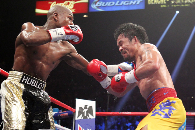Floyd Mayweather Jr. hits Manny Pacquiao with a left during their welterweight unification boxing match at the MGM Grand Garden Arena in Las Vegas on Saturday, May 2, 2015. (Sam Morris/Las Vegas R ...