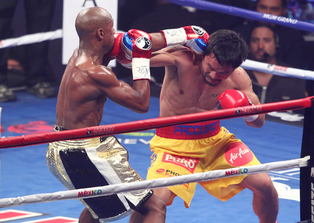 Floyd Mayweather Jr., left, trades punches with Manny Pacquiao in their welterweight unification boxing match at the MGM Grand Garden Arena in Las Vegas on Saturday, May 2, 2015. (Chase Stevens/La ...