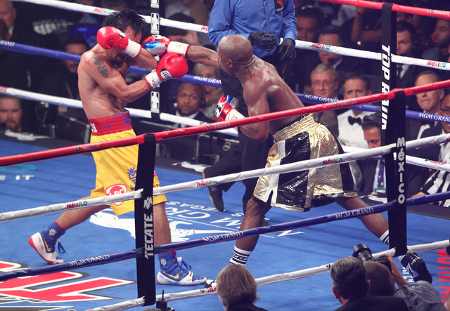 Floyd Mayweather Jr., right, connects with Manny Pacquiao in their welterweight unification boxing match at the MGM Grand Garden Arena in Las Vegas on Saturday, May 2, 2015. (Chase Stevens/Las Veg ...
