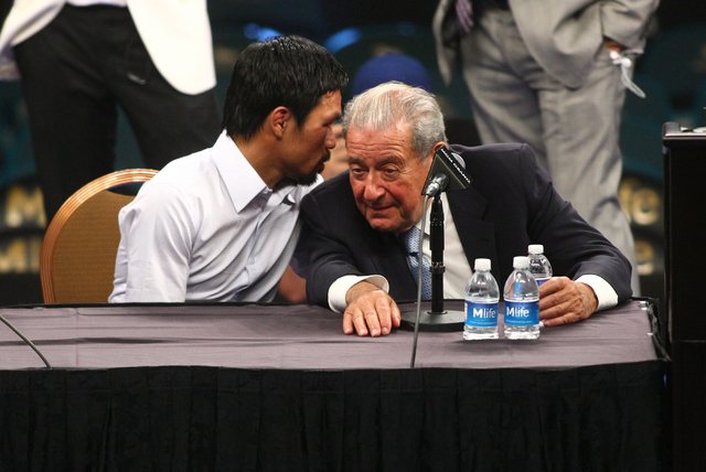Manny Pacquiao, left, talks with promoter Bob Arum following Pacquiao's defeat by Floyd Mayweather Jr. after their welterweight unification boxing match at the MGM Grand Garden Arena in Las Vegas  ...