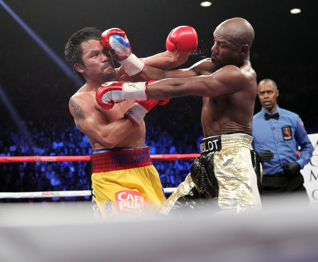 Floyd Mayweather Jr., left, and Manny Pacquiao mix it up in the eighth round of their welterweight unification boxing match at the MGM Grand Garden Arena in Las Vegas on Saturday, May 2, 2015. (Sa ...