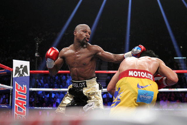 Floyd Mayweather Jr. lands a left to Manny Pacquiao in the ninth round of their welterweight unification boxing match at the MGM Grand Garden Arena in Las Vegas on Saturday, May 2, 2015. (Sam Morr ...