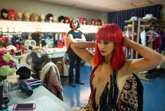 Lisa Cannon adjusts her wig before performing in "Crazy Girls" as wardrobe supervisor Holly McKinnis looks on Friday, Feb. 14, 2014 at the Riviera Hotel and Casino. McKinnis is a theatre ...