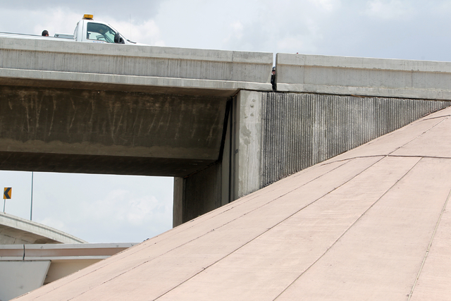 Officials from the Nevada Department of Transportation and Nevada Highway Patrol troopers investigate possible damage on the ramp from southbound U.S. Route 95 to southbound Interstate 15 on Frida ...