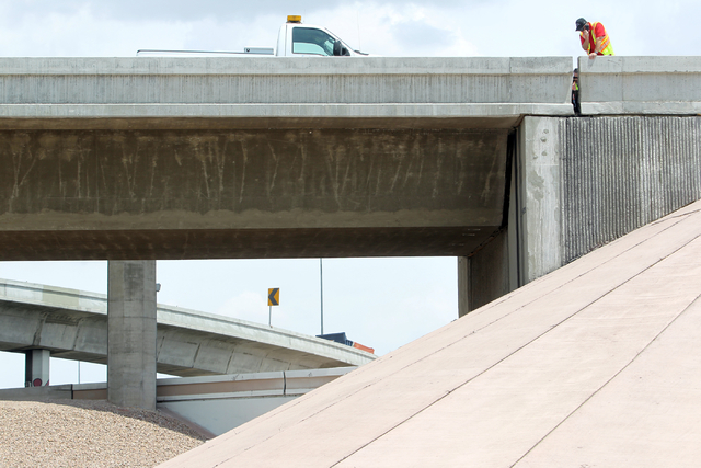 Officials from the Nevada Department of Transportation and Nevada Highway Patrol troopers investigate possible damage on the ramp from southbound U.S. Route 95 to southbound Interstate 15 on Frida ...