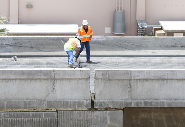 Officials from the Nevada Department of Transportation investigate possible damage on the ramp from southbound U.S. Route 95 to southbound Interstate 15 on Friday, May 22, 2015. A 4.8-magnitude ea ...