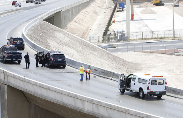 Officials from the Nevada Department of Transportation and Nevada Highway Patrol investigate possible damage on the ramp from southbound U.S. Route 95 to southbound Interstate 15 on Friday, May 22 ...