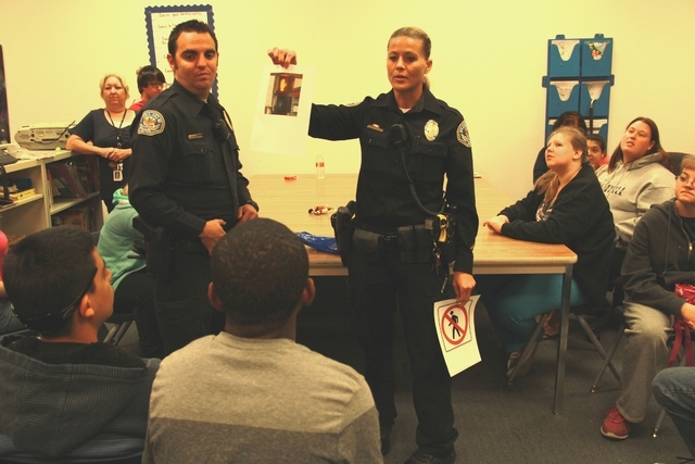 Henderson police officers Russell Adams and Lindsay Vukanovich show photos of crosswalk signals to special needs students Nov. 14 at Foothill High School, 800 College Drive, while teaching them ab ...