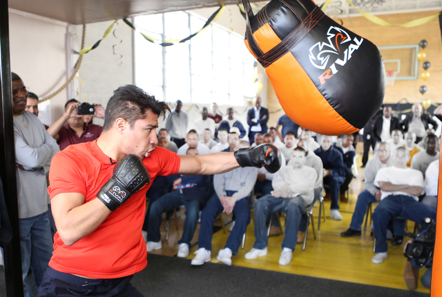Youth watch as boxer Jessie Vargas gives a lesson on how to use a heavy punching bag at the Spring Mountain Youth Camp Wednesday, April 22, 2015. Professional boxers and boxing referees visited th ...