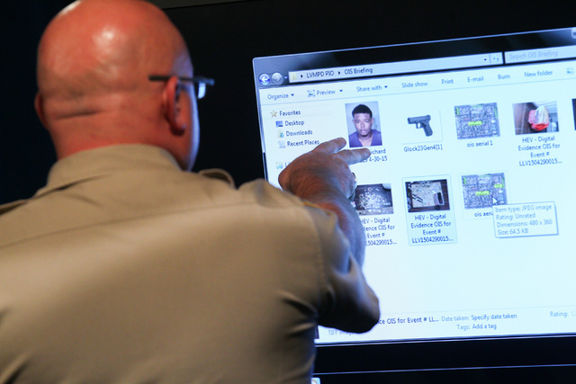 Las Vegas police officials look over images before Undersheriff Kevin McMahill addresses news media about an officer-involved shooting that took place April 29, at Las Vegas police headquarters on ...