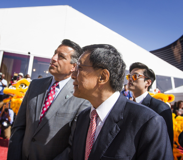 K.T. Lim, chairman, center and CEO of Genting Group, walks with Gov. Brian Sandoval during the groundbreaking of the $4 billion Resorts World Las Vegas resort property, the site of the former S ...