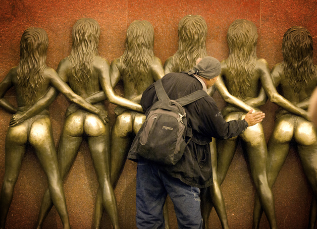 A man slaps the statue of the Crazy Girls in front of the Riviera hotel-casino, 2901 Las Vegas Blvd. South, on Monday, April 20, 2015. The resort will close Monday, May 4, to make room for Las Ve ...