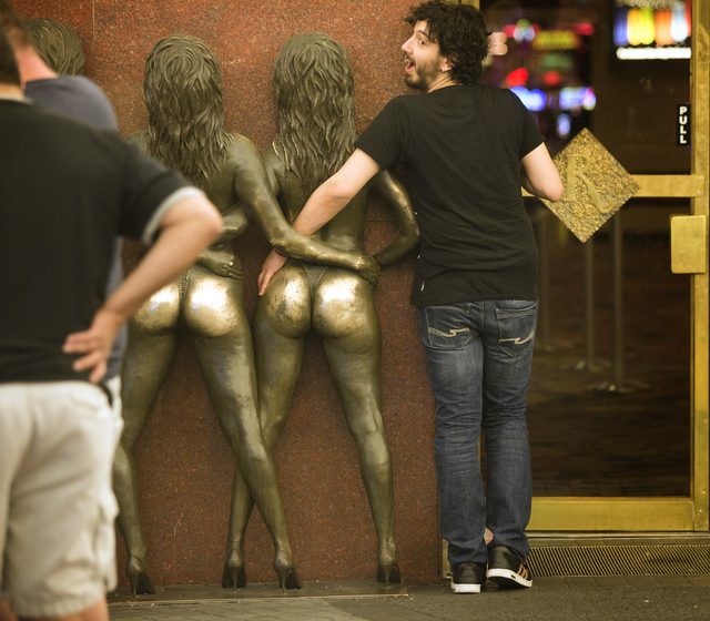 A man mugs for a photo with the statue of the Crazy Girls in front of the  Riviera hotel-casino, 2901 Las Vegas Blvd. South, on Monday, April 20, 2015. The resort will close Monday, May 4, to make ...