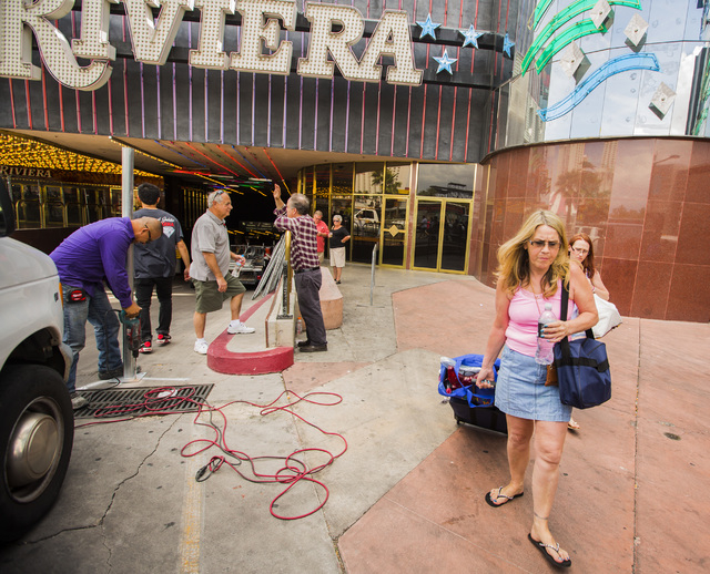 People leave the the Riviera hotel-casino while construction crews erect fencing on Monday, May 4, 2015. The casino closed Monday after 60 years on the Las Vegas Strip. (Jeff Scheid/Las Vegas Revi ...