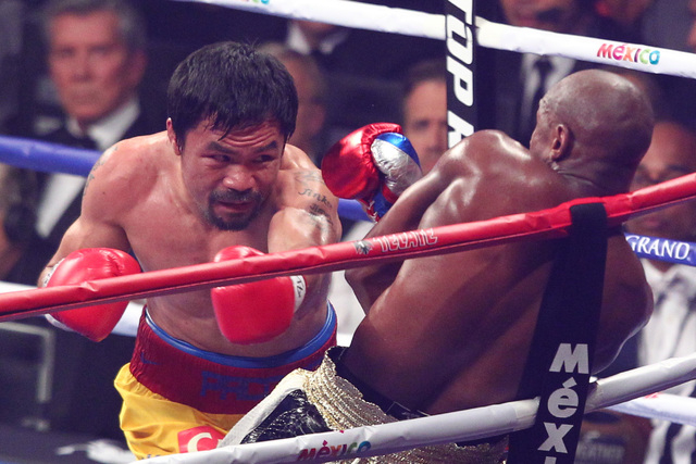 Floyd Mayweather Jr., right, dodges a punch from Manny Pacquiao in their welterweight unification boxing match at the MGM Grand Garden Arena in Las Vegas on Saturday, May 2, 2015. (Chase Stevens/L ...