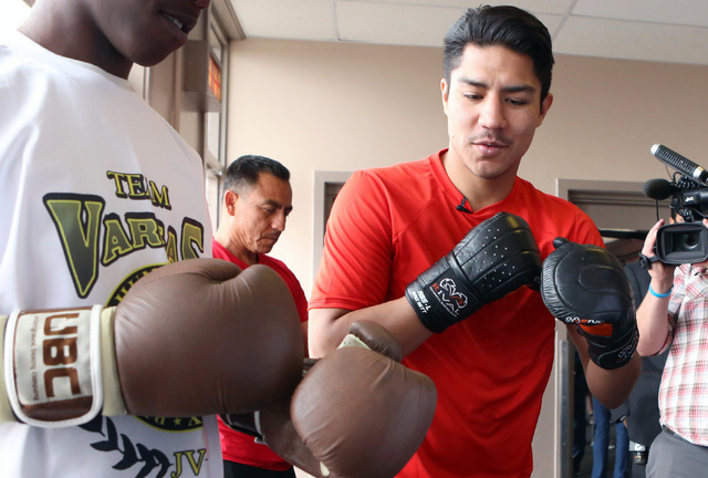 Boxer Jessie Vargas, right, gives boxing lessons to a young boxer at the Spring Mountain Youth Camp Wednesday, April 22, 2015.   Professional boxers and boxing referees visited the camp, where you ...