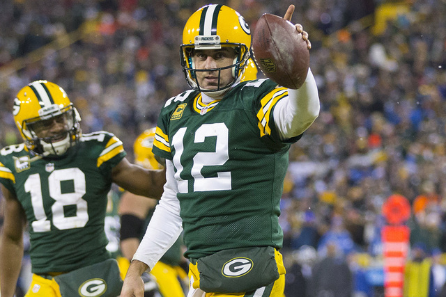 Dec 28, 2014; Green Bay, WI, USA; Green Bay Packers quarterback Aaron Rodgers (12) celebrates after scoring a touchdown during the fourth quarter against the Detroit Lions at Lambeau Field.  Green ...