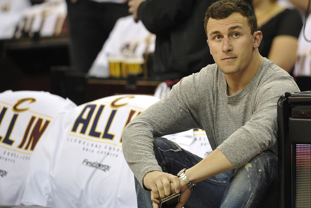Apr 19, 2015; Cleveland, OH, USA; Cleveland Browns quarterback Johnny Manziel sits in the front row prior to game one of the first round of the NBA Playoffs at Quicken Loans Arena. (David Richard/ ...
