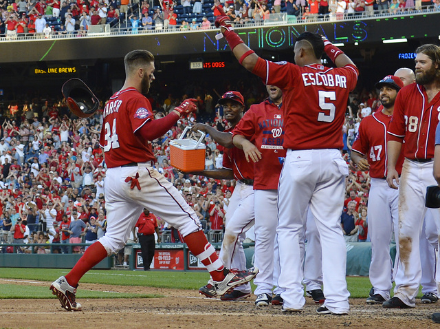 May 9, 2015; Washington, DC, USA;  Washington Nationals right fielder Bryce Harper (34) celebrates with his teammates after hitting a two run walk off home run off Atlanta Braves relief pitcher Co ...