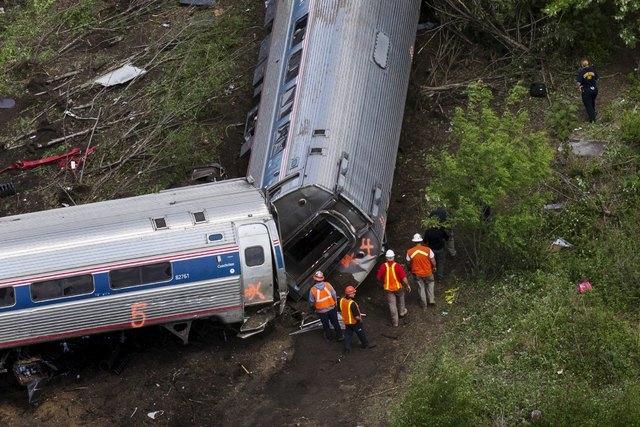 Emergency workers and Amtrak personnel inspect a derailed Amtrak train in Philadelphia, May 13, 2015.  The commuter rail route where an Amtrak train left the track on Tuesday was not governed by a ...