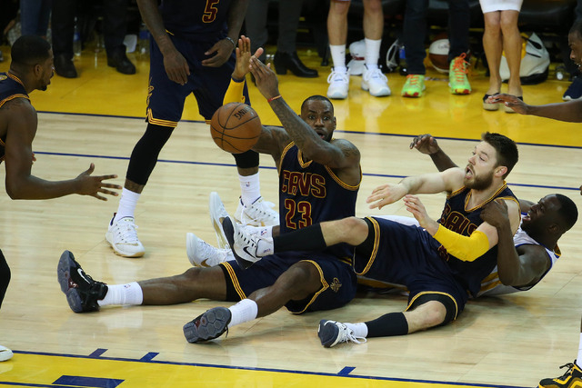 Cleveland Cavaliers forward LeBron James (23) tries to call a time out as guard Matthew Dellavedova (8) passes the ball to center Tristan Thompson (13) against the Golden State Warriors during the ...