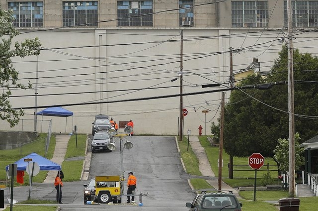 New York State Correctional Services officers (bottom) stand near a manhole at the corners of Bouck and Barker streets where two convicted murderers are believed to have emerged after escaping fro ...