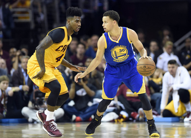 Jun 9, 2015; Cleveland, OH, USA; Golden State Warriors guard Stephen Curry (30) handles the ball against Cleveland Cavaliers guard Iman Shumpert (4) during the third quarter in game three of the N ...