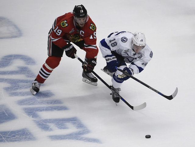 Jun 10, 2015; Chicago, IL, USA; Chicago Blackhawks center Jonathan Toews (19) and Tampa Bay Lightning left wing Ondrej Palat (18) chase after the puck during the third period of game four of the 2 ...