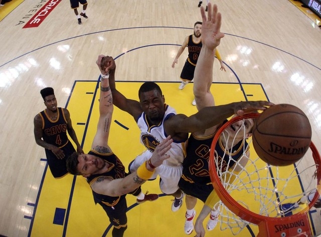 Golden State Warriors forward Harrison Barnes (40) dunks the ball over Cleveland Cavaliers guard Mike Miller (18) and center Timofey Mozgov (20) in game five of the NBA Finals at Oracle Arena on J ...