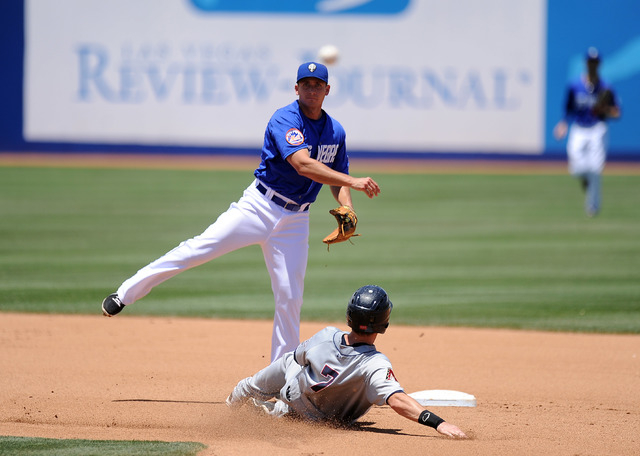 Las Vegas 51s second baseman T.J. Rivera turns a double play as Reno Aces base runner Danny Dorn (7) slides into the base in the fourth inning of their Triple-A minor league baseball game at Cashm ...