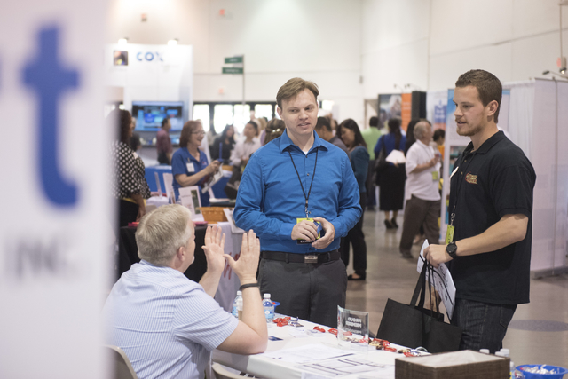 From bottom left, Jess Marlow, director of business development, and Jesse Bethke, chief operations officer, both with Smart Software Solutions, inc. speak with Erick Briggs, marketing manager for ...