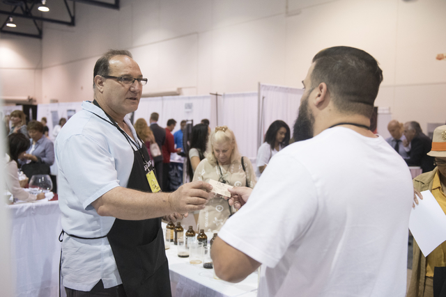 Left, Richard Karno, owner of Lucky Jack Iced Coffee, hands a business card to Billy Armanino of Pink Box Doughnuts during the Las Vegas Metro Chamber Of Commerce Business Expo at Cashman Center i ...