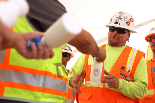Deck foreman Russell Harris receives a water bottle following a presentation hosted by the PENTA Building Group on the safety hazards heat brings at the Lucky Dragon casino-hotel construction site ...