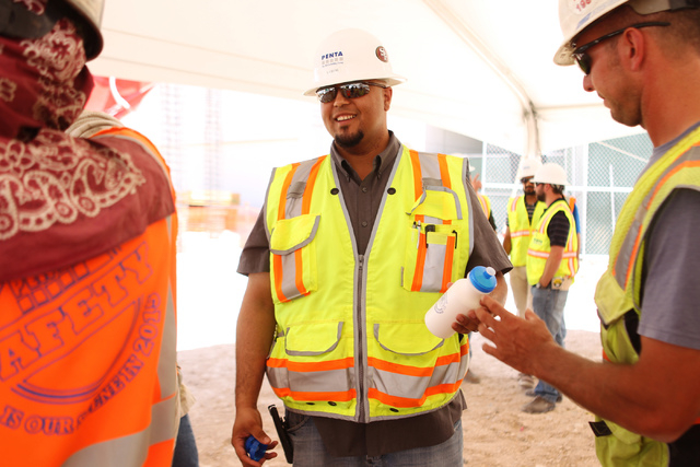 Elias Brooks hands out water bottles following a presentation hosted by the PENTA Building Group on the safety hazards heat brings at the Lucky Dragon casino-hotel construction site in Las Vegas o ...