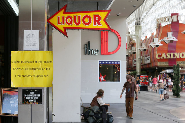 Signs are posted at the entrance to a gift shop that sells liquor at Fremont Street Experience, July 17, 2014, in Las Vegas. A series of liquor ordinances are in effect regulating alcohol carrying ...