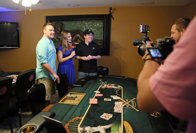 Bradley Anderson, left, and professional poker player Jamie Gold, third from left, take part in an interview with Lizzy Harrison, second from left, of All In Magazine, after playing a heads up tou ...