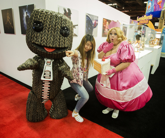 Performers dressed in cartoon characters Sack Boy, left, and  Fat Princess,right, poises for a photo with a fan in the Licensing Expo 2015 at the Mandalay Bay Convention Center, 3950 South Las Veg ...