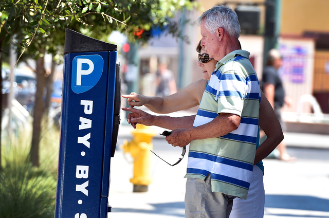 Tourists Marv and Jean Junk of Iowa feed a parking meter along 7th Street in downtown Las Vegas on Friday, June 12, 2015. (David Becker/Las Vegas Review-Journal)