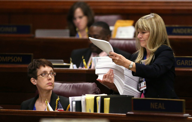 Nevada Assemblywoman Heidi Swank, D-Las Vegas, gets paperwork from Assistant Sgt.-at-Arms Vickie Kieffer during Assembly floor action in the final hours of the session at the Legislative Building  ...