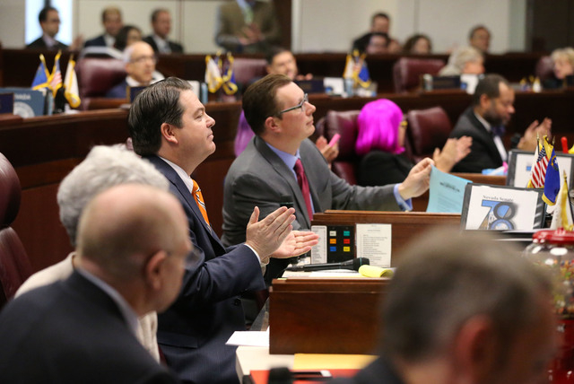 Nevada Senate Majority Leader Michael Roberson, R-Henderson, center, applauds as a record $1.1 billion general fund tax package receives passage on the Senate floor at the Legislative Building in  ...