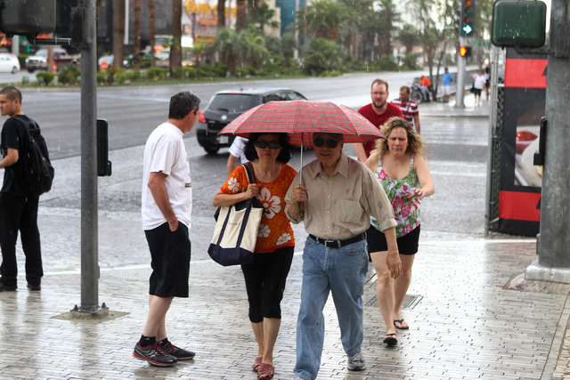 A couple who declined to be identified walk under their umbrella near New York-New York casino-hotel in Las Vegas Sunday, June 14, 2015. (Erik Verduzco/Las Vegas Review-Journal) Follow Erik Verduz ...