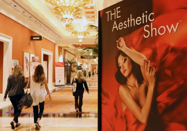 Show attendees walk past a banner for THE Aesthetic Show at Wynn hotel-casino Friday, July 10, 2015, in Las Vegas. (Ronda Churchill/Las Vegas Review-Journal)