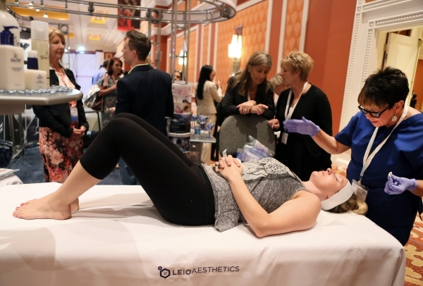 Ellice Turner, front, receives a VisaoMD Brilliance Peel by Valerie Zehler, right, a medical esthetician, during The Aesthetic Show on July 10 at Wynn hotel-casino. (Ronda Churchill/Las Vegas Revi ...