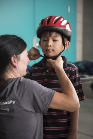 Shannon Gaffney fits Adriel Tabilog, 6, with a helmet at the bicycle helmet giveaway at Black Mountain Recreation Center in Henderson, Saturday, July 18, 2015. (Jason Ogulnik/Las Vegas Review-Journal)