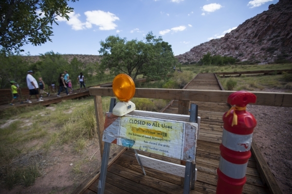 A blocked off portion of the boardwalk is seen as people walk by at the Red Springs picnic area in the Red Rock Canyon National Conservation Area on Tuesday, July 21, 2015. A portion of the boardw ...